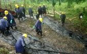 Trabajadores limpian un derrame petrolero en la amazonía peruana.