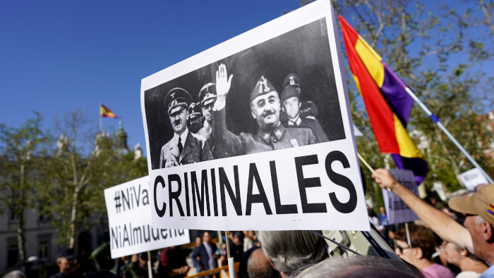 Un manifestante levanta una pancarta en un protesta frente al Tribunal Supremo español.