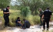 Migrant men sit on the ground after being detained by law enforcement for illegally crossing the Rio Grande and attempting to evade capture in Hidalgo, Texas, U.S., August 23, 2019.
