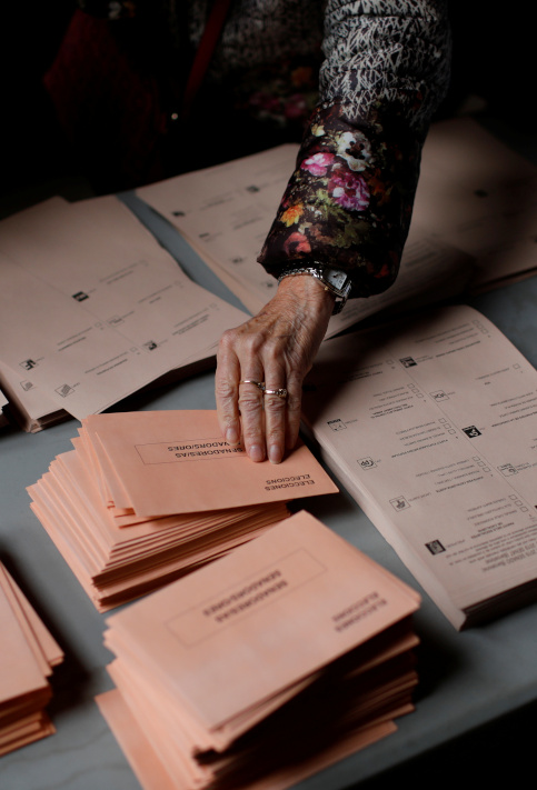 Una persona recoge un sobre durante las elecciones generales en Barcelona, España.