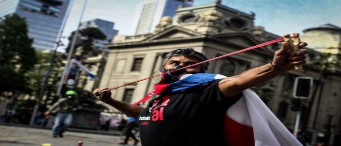 Protester defending himself with a slingshot (Santiago, Chile, Nov.11, 2019).