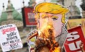 Activistas del Centro de Unidad Socialista de India (SUCI) queman un dibujo de Trump durante una protesta contra la visita del presidente de EE.UU.