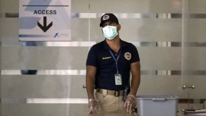 Un agente de seguridad usa una mascarilla como protección en el Aeropuerto Internacional de Toncontín, en Tegucigalpa.