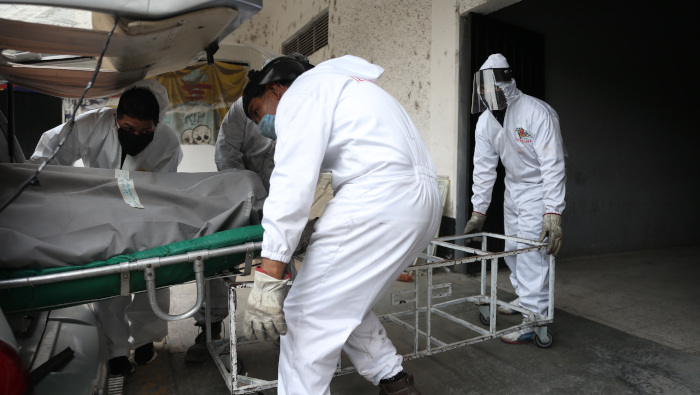Trabajadores de un panteón de la Ciudad de México trasladan a la zona de crematorios el cuerpo de una persona fallecida por Covid-19.