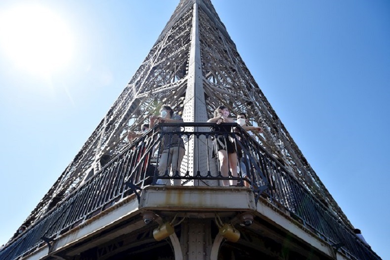 Desde el segundo piso de la Torre Eiffel, los turistas observan vistas panorámicas de la ciudad, y toman fotografías de estas. Los ascensores más grandes funcionarán a partir de julio.    