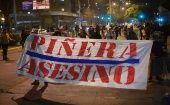 En Santiago unas 50 personas concentradas en Plaza Ñuñoa portaban pancartas que exigían la renuncia del presidente.