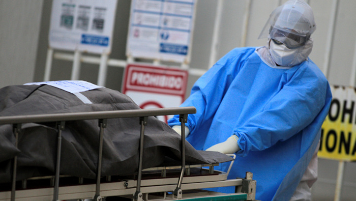 Un empleado de la salud traslada a la morgue a una víctima de la Covid-19 el martes en México.