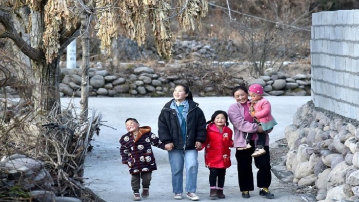 Bamu y su familia en la nueva aldea de Taoyuan, que cuenta con servicios de agua, electricidad, telecomunicaciones y modernas carreteras..