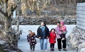 Bamu y su familia en la nueva aldea de Taoyuan, que cuenta con servicios de agua, electricidad, telecomunicaciones y modernas carreteras..