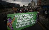 The banner reads, "Mothering, aborting, deciding, and fighting in community," Ecuador.