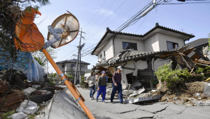 Los residentes inspeccionan las carreteras dañadas y las casas derribadas en la ciudad de Mashiki, prefectura de Kumamoto, después de un gran terremoto en abril de 2016.
