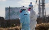 Japanese workers wearing radiation protection suits in Fukushima, Feb. 2024.