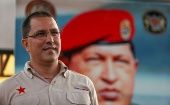 Jorge Arreaza in front of a giant photograph of Commander Hugo Chavez.