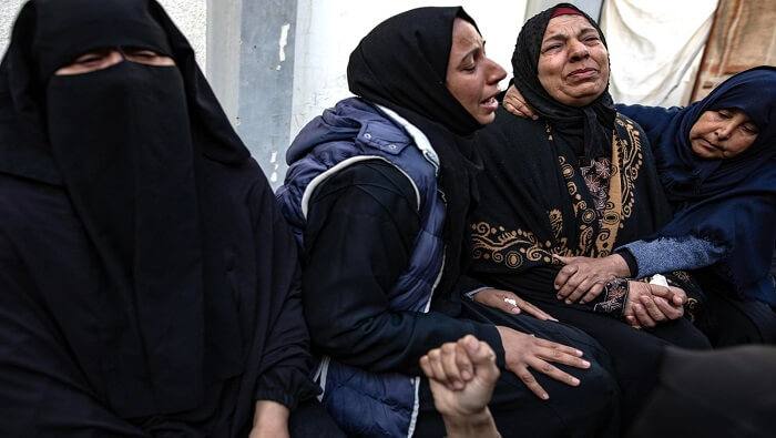 Mujeres palestinas se consuelan entre sí tras haber perdido a sus familiares en un bombardeo israelí.