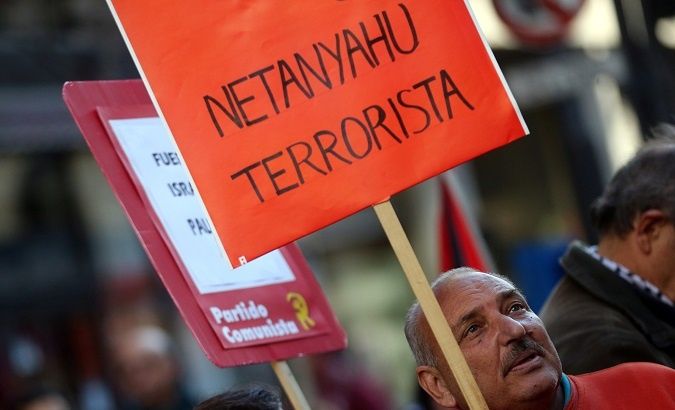 A man holds a sign that reads 'Netanyahu terrorist' 