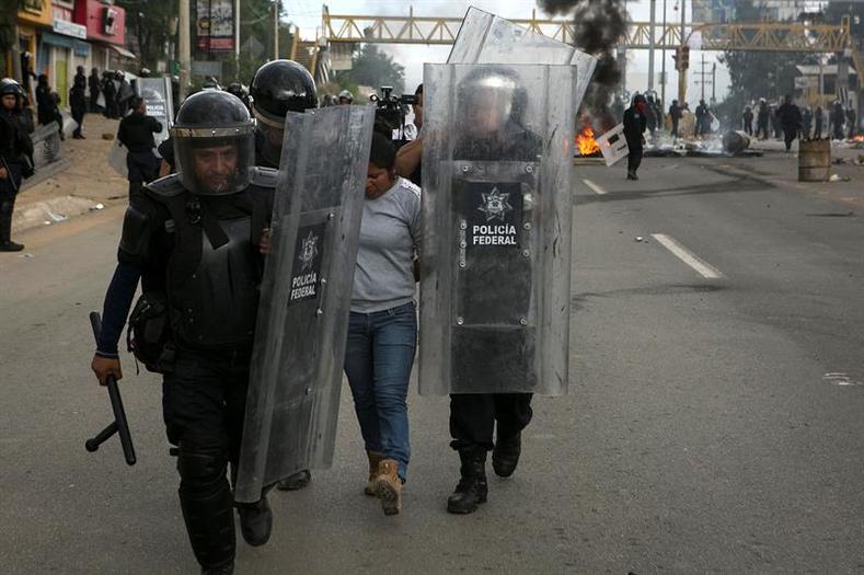 Federal Police detain a protester following battles to clear blockades on the highways surrounding Oaxaca City.