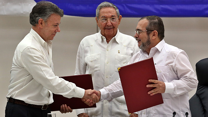 Juan Manuel Santos y Rodrigo Londoño sostienen el acuerdo de paz.