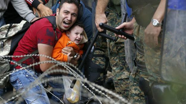 Un padre y su hijo intentan cruzar la frontera de Macedonia, 2015.