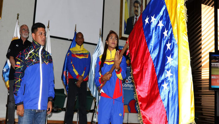 Jeserik Pinto recibió el tricolor venezolano de manos del ministro Infante (i).