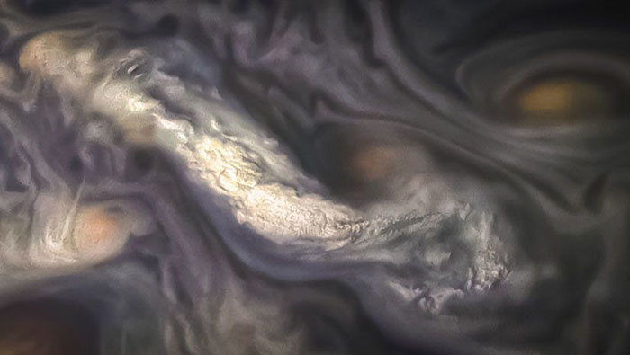La fotografía muestra las nubes extrañas de gran altitud, rodeadas por remolinos en la atmósfera del Cinturón Templado Norte Norte de Júpiter, conformado por muchos anillos de nubes tumultuosas de varios colores.