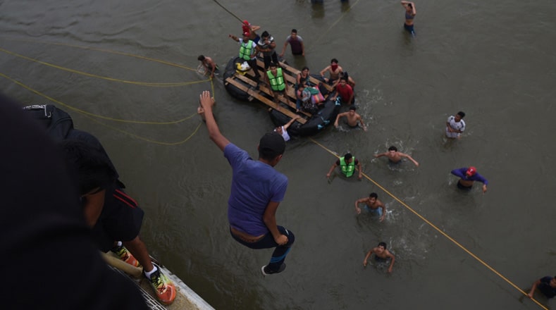 Los migrantes centroamericanos que se dirigen a Estados Unidos en busca de mejores condiciones de vida, cruzan el río Suchiate nadando sujetados por una cuerda.