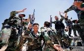 Militares sirios celebran la toma de la ciudad de Manjib, en el norte de Siria, donde izaron la bandera nacional en defensa de la soberanía. 