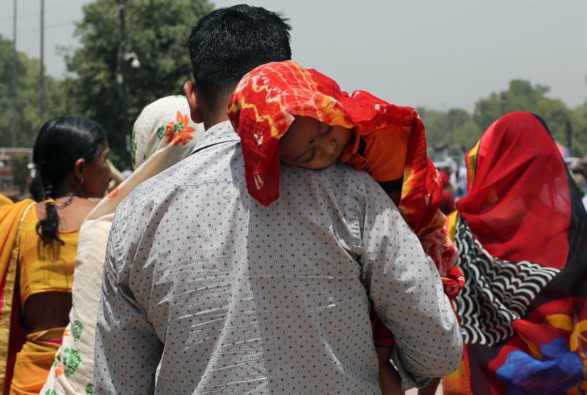 Niño con un pañuelo para protegerlo de las altas temperaturas en Nueva Delhi.