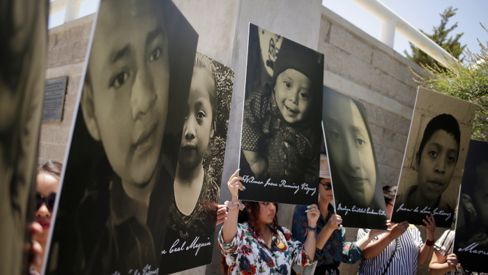 Activistas sostienen fotos de niños migrantes que mueren bajo custodia en EE.UU.