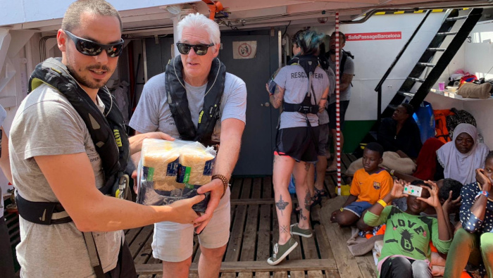 El actor Richard Gere ayuda a transportar suministros a bordo del barco de rescate Open Arms.