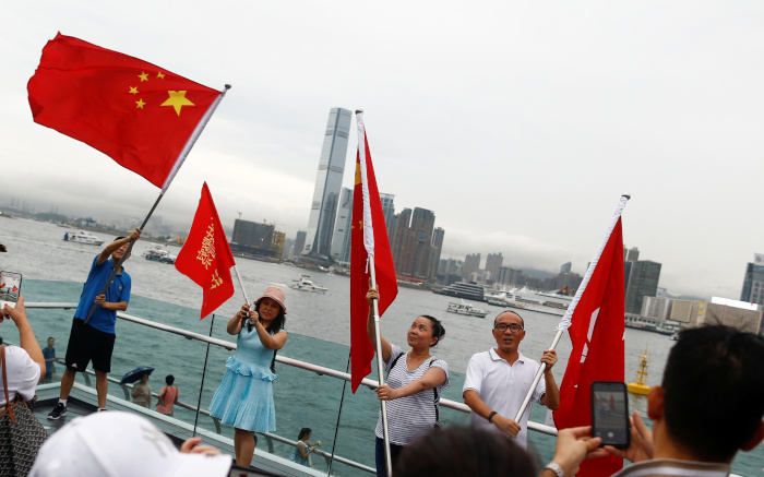 Manifestantes sostienen banderas de China en la marcha para 