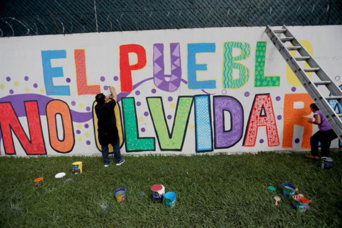 Ciudadanos y miembros de colectivos sociales pintan un mural frente a la sede de la CICIG como despedida.