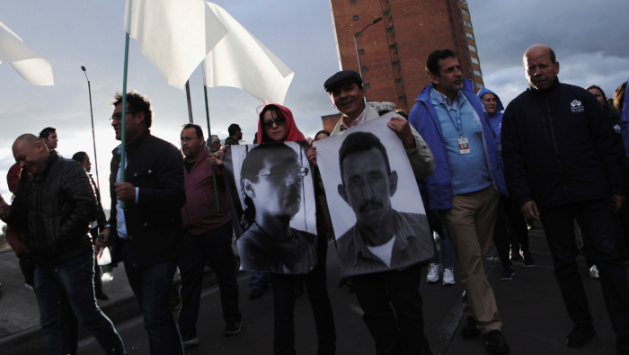 En una protesta de julio pasado en Bogotá, manifestantes sostienen fotografías de líderes sociales asesinados.