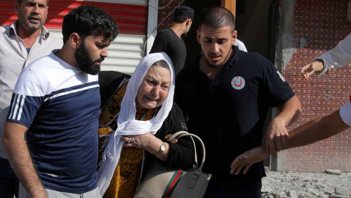 Una mujer es sacada de un edificio después de ser alcanzada por proyectiles en la ciudad turca de Akcakale, en la frontera con Siria.