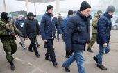 Un grupo de hombres escoltado durante el intercambio de prisioneros de guerra en la región de Donetsk.