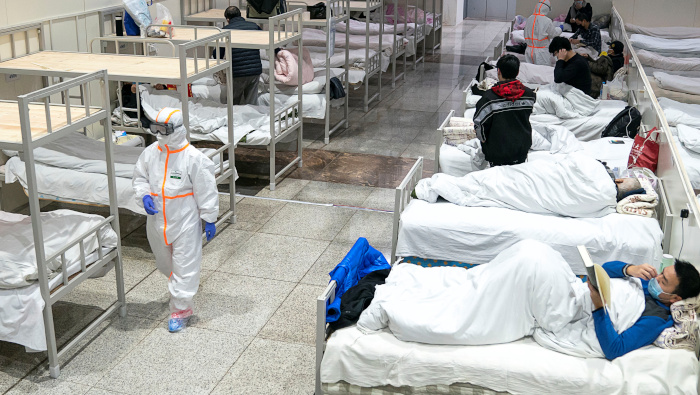 Trabajadores médicos atienden a pacientes en el Centro Internacional de Exposiciones de Wuhan, adaptado como un hospital.
