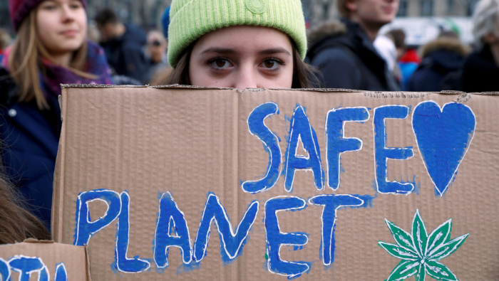 Una activista del movimiento 'Fridays for Future' sostiene una pancarta con un lema ecologista.