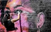 Una mujer retoca un mural sobre Marielle Franco, en una favela de Río de Janeiro, Brasil.