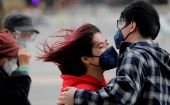 Dos personas con mascarillas caminan durante el clima ventoso en Beijing, China, el 18 de marzo de 2020.