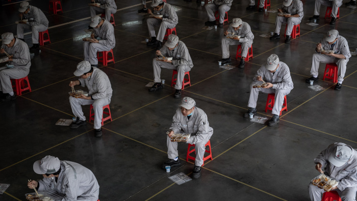 Trabajadores de una fábrica de Wuhan, en la provincia china de Hubei, almuerzan guardando la sana distancia de seguridad.