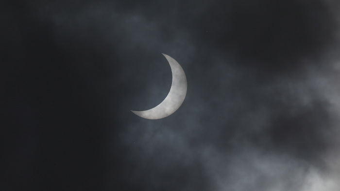 El eclipse solar anular parcial visto este domingo en el cielo nublado sobre las afueras de Nueva Delhi, India.