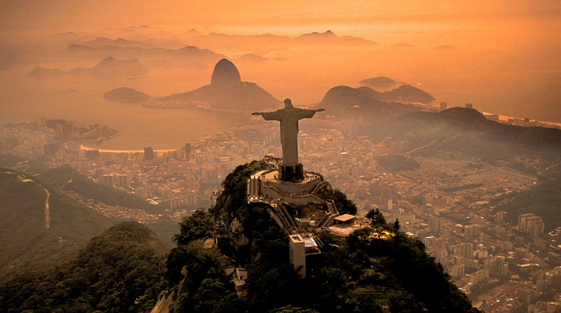 A sus 700 metros de altitud, el Cristo Redentor es el ángel guardián de la ciudad brasileña de Río de Janeiro. Desde su mirador, se puede apreciar el bello atardecer de una urbe donde se mezclan la alegría y la poesía.