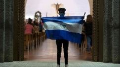 Young man waves Nicaragua's flag at the entrance of a church in Managua, April 19, 2020. 