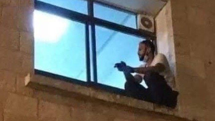 Foto viral en redes sociales del palestino en la ventana del cuarto donde su madre estaba hospitalizada.