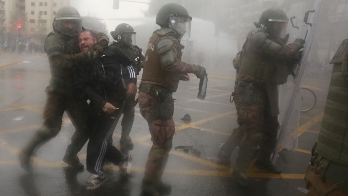 Elementos de Carabineros arrestan a un hombre durante una protesta en contra del Gobierno chileno.