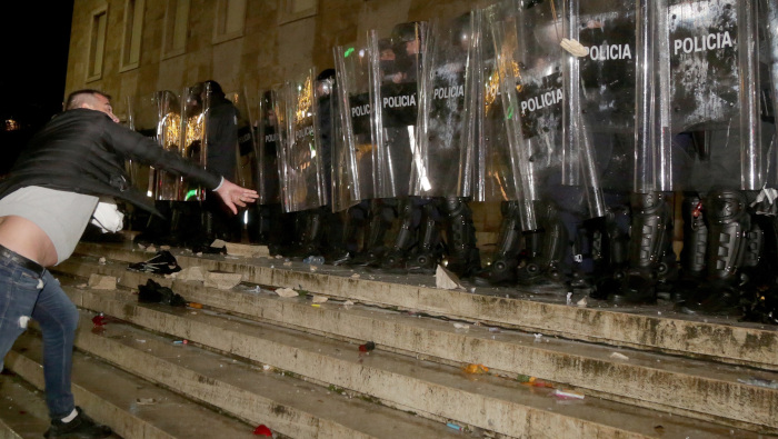 Un manifestante arroja piedras a las fuerzas de la policía antidisturbios durante una protesta en Tirana, Albania.