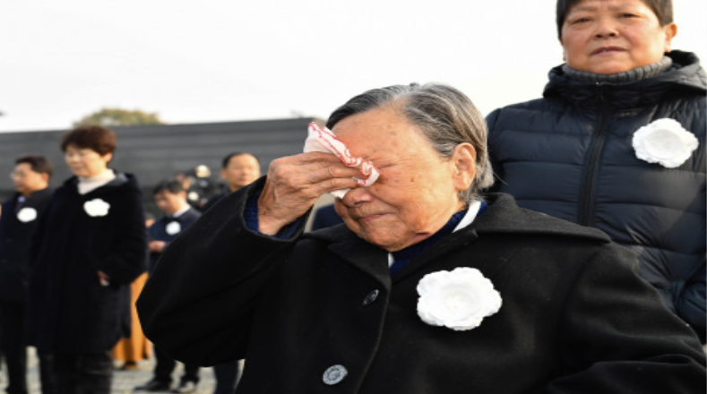 Varios sobrevientes del horror que los invasores japoneses perpetuaron hace más de 80 años en Nanjing, lloran en la ceremonia que rinde tributo a las víctimas de aquellos hechos.
