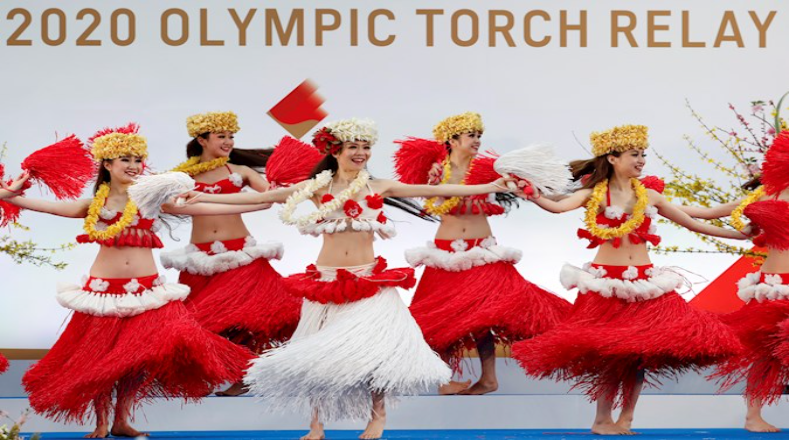 La apertura del primer día del relevo de la antorcha olímpica de Tokio 2020 inició con la presentación de grupos artísticos como el Spa Resort Hawaiians "Hula Girls" en una ceremonia a puerta cerrada para el público para evitar aglomeraciones que pudieran contribuir con la propagación de la Covid-19. 