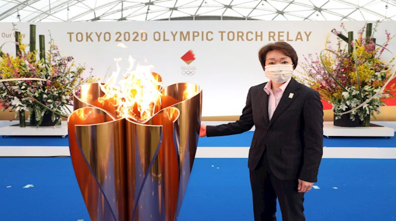 La presidenta del Comité Organizador de Tokio 2020, Seiko Hashimoto, encabezó la ceremonia que marca la primera etapa del relevo de la antorcha de los Juegos Olímpicos de Tokio, y expresó que "esta pequeña llama nunca perdió la esperanza y ha esperado este día como una yema de cerezo a punto de florecer"..