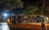 En las imágenes difundidas por la prensa local se ve el autobús volcado de costado, en medio de los restos de la valla de seguridad.