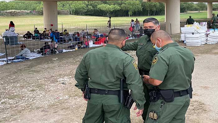 Agentes de la Patrulla Fronteriza de EE.UU. vigilan a un grupo de migrantes en la frontera con México.